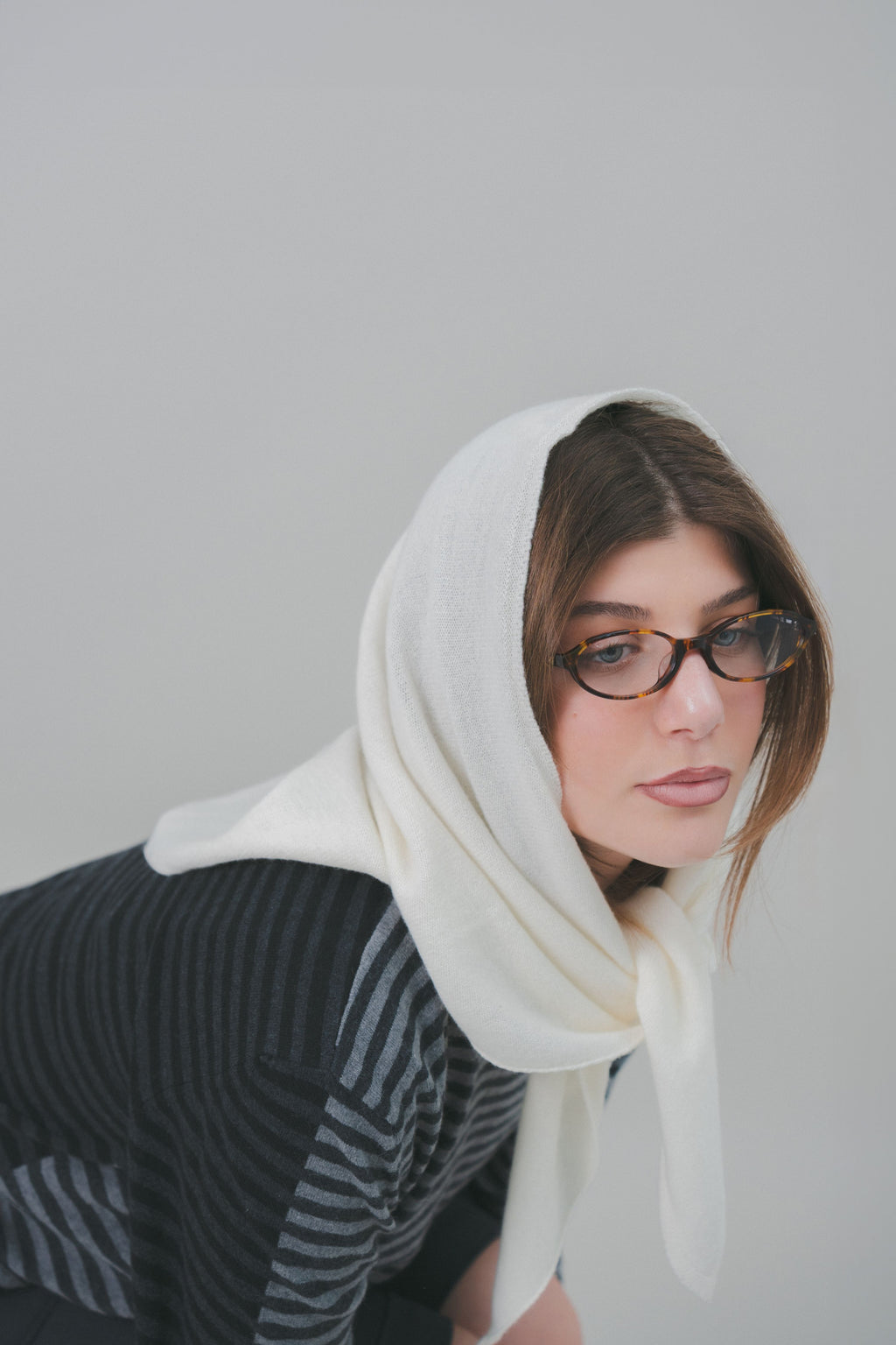 Contemporary look with the white Costa Knit Atelier Triangle Scarf, highlighting artisanal local production and natural fibers premium cashmere and merino wool.