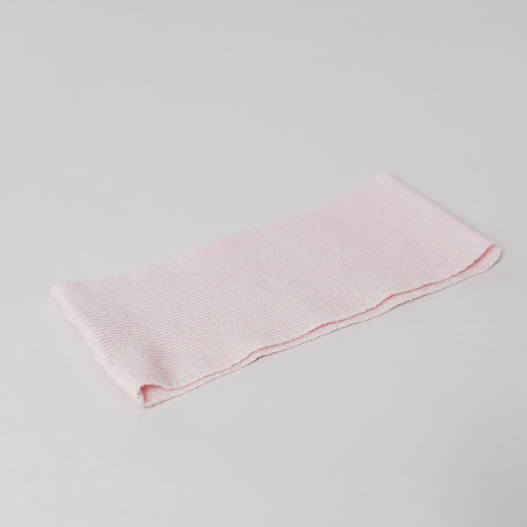 Flat lay of the pink Headband by Costa Knit Atelier, handcrafted from a premium cashmere and extra-fine merino wool blend for ultimate comfort.