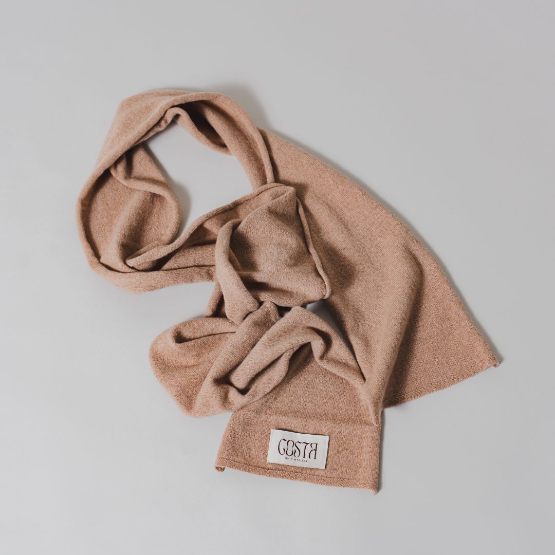 Flat lay of the Beige Thin Scarf by Costa Knit Atelier, a premium cashmere and merino wool blend with a 90s minimalist silhouette."