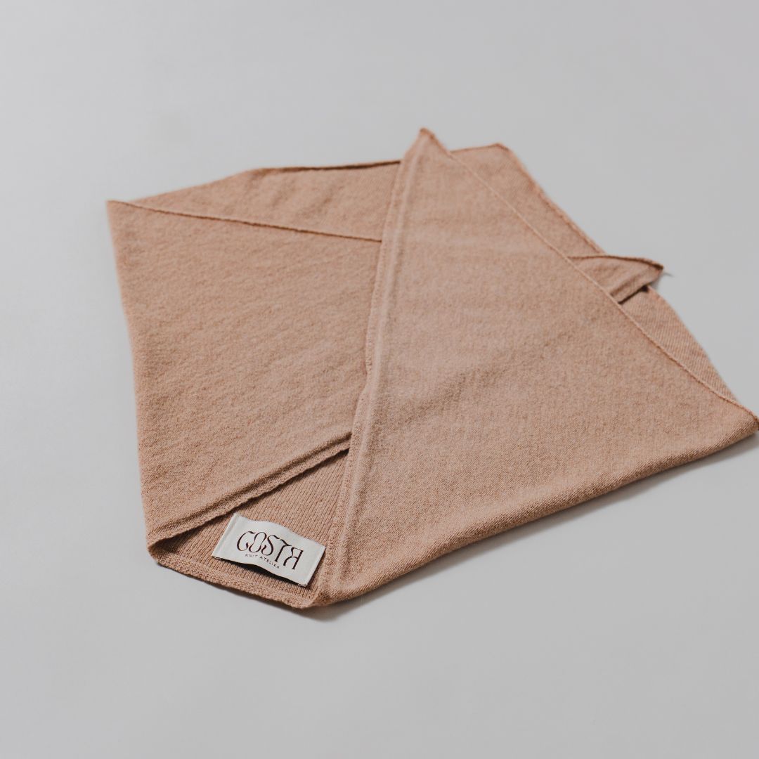 Flat lay of The Triangle Scarf by Costa Knit Atelier, handcrafted in premium beige cashmere and merino wool blend.