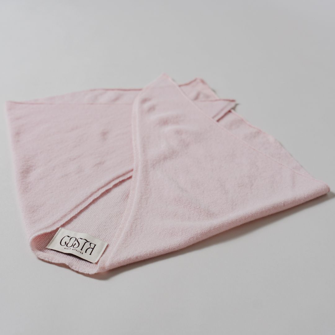 Flat lay of The Triangle Scarf by Costa Knit Atelier, handcrafted in premium pink cashmere and merino wool blend